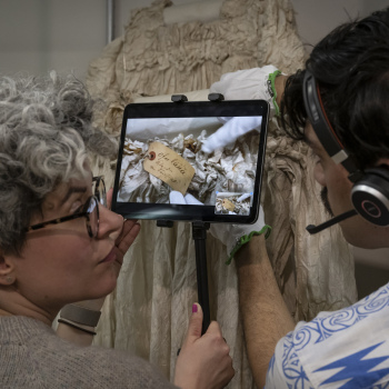 Two people looking at a mobile device filming an object